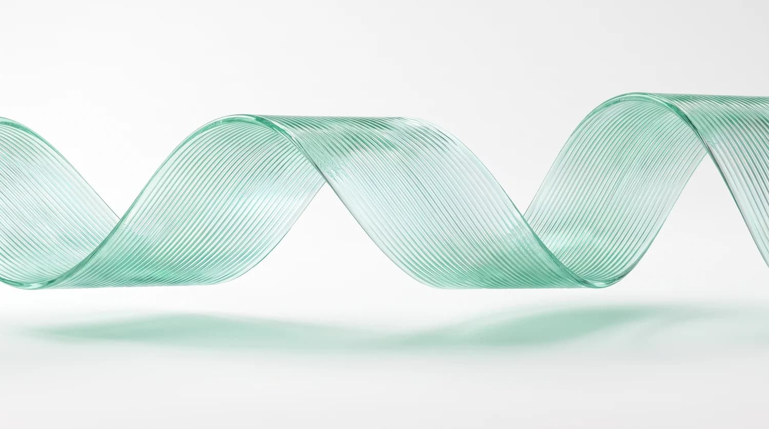 A translucent mint ribbon sweeping through a pale studio setting.
